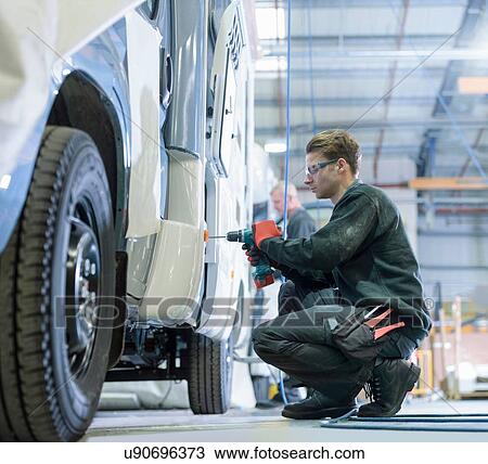 Stock Image - Workers on motorhome production line. Fotosearch
