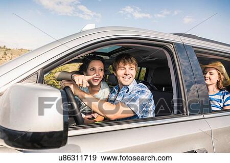 Young adult friends looking out and pointing from vehicle window, Bridger, Montana, USA View Large Photo Image Stock Photo - Young adult friends looking out and pointing from vehicle window, Bridger, Montana, USA. Fotosearch