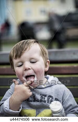Stock Photograph - Young boy eating an ice cream. Fotosearch