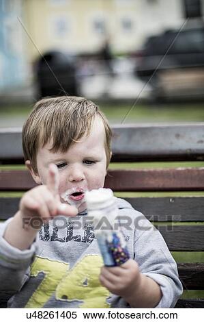 Stock Photography - Young boy eating an ice cream. Fotosearch