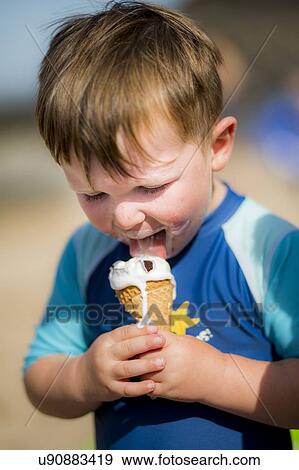Stock Photo - Young boy licking an ice cream. Fotosearch