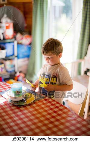 Picture - Young boy setting the table at home. Fotosearch