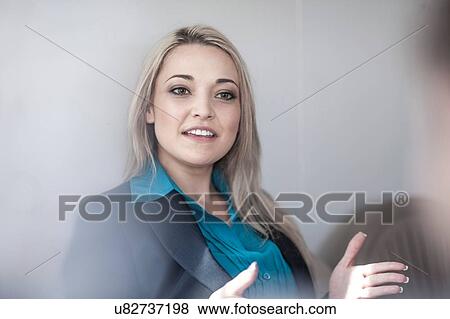Young businesswoman explaining to male colleague in office View Large Photo Image Stock Photo - Young businesswoman explaining to male colleague in office. Fotosearch