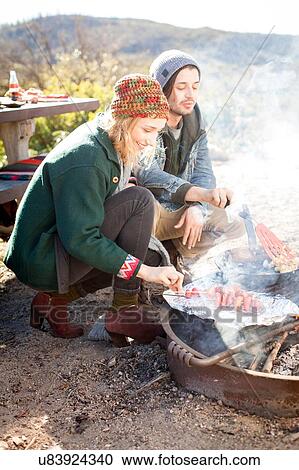 "Young couple cooking food outdoors, in rural setting" View Large Photo Image Stock Image - "Young couple cooking food outdoors, in rural setting". Fotosearch