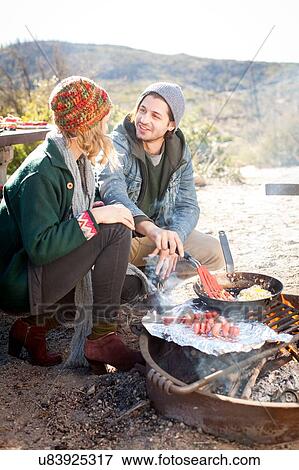 "Young couple cooking food outdoors, in rural setting" View Large Photo Image Stock Photo - "Young couple cooking food outdoors, in rural setting". Fotosearch