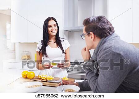 Young couple couple eating breakfast at kitchen counter View Large Photo Image Stock Image - Young couple couple eating breakfast at kitchen counter. Fotosearch