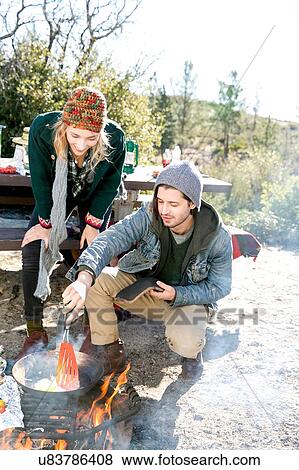 "Young couple in rural setting, cooking food over camp-fire" View Large Photo Image Stock Photo - "Young couple in rural setting, cooking food over camp-fire". Fotosearch