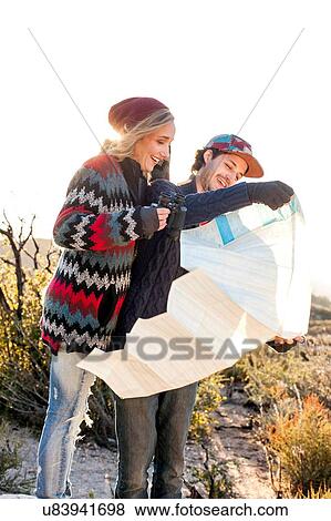 Stock Photo - "Young couple in rural setting, looking at map". Fotosearch
