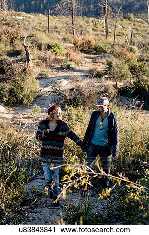 "Young couple in rural setting, walking, holding hands" View Large Photo Image Stock Image - "Young couple in rural setting, walking, holding hands". Fotosearch