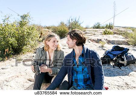 Picture - "Young couple outdoors, taking a break from hiking". Fotosearch
