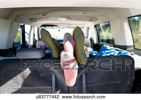 Stock Image - "Young couple relaxing in recreational vehicle, focus on feet". Fotosearch