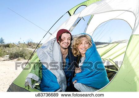 "Young couple sitting in tent, wrapped in sleeping bags" View Large Photo Image Stock Photo - "Young couple sitting in tent, wrapped in sleeping bags". Fotosearch