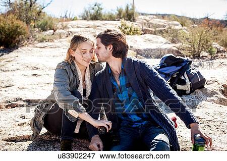 Stock Photo - "Young couple sitting, relaxing, in rural setting". Fotosearch