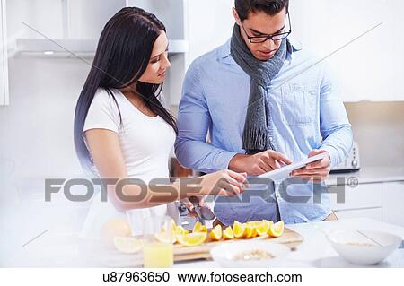 Young couple using digital tablet at kitchen counter View Large Photo Image Stock Image - Young couple using digital tablet at kitchen counter. Fotosearch