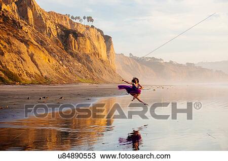 "Young female dancer, jumping, in mid air, over water at beach, San Diego, California, USA" View Large Photo Image Stock Image - "Young female dancer, jumping, in mid air, over water at beach, San Diego, California, USA". Fotosearch