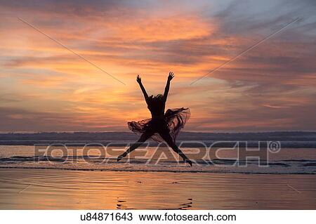 "Young female dancer wearing chiffon dress, dancing, in mid air, on beach at sunset, San Diego, California, USA" View Large Photo Image Stock Image - "Young female dancer wearing chiffon dress, dancing, in mid air, on beach at sunset, San Diego, California, USA". Fotosearch