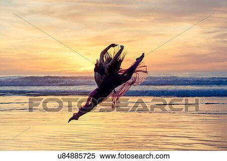 "Young female dancer wearing chiffon dress, dancing, in mid air, on beach at sunset, San Diego, California, USA" View Large Photo Image Stock Photography - "Young female dancer wearing chiffon dress, dancing, in mid air, on beach at sunset, San Diego, California, USA". Fotosearch