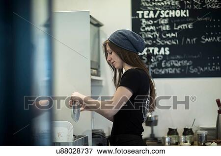 Young female waitress working in cafe kitchen View Large Photo Image Stock Photo - Young female waitress working in cafe kitchen. Fotosearch