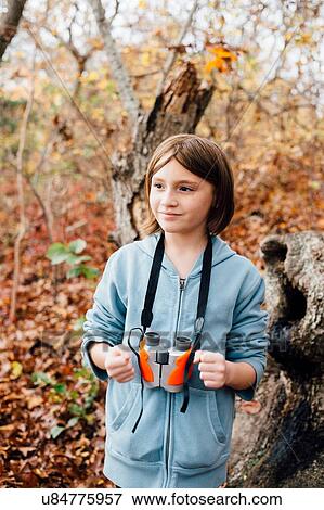 Stock Photo - "Young girl in forest, binoculars round neck". Fotosearch