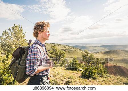 Young male hiker looking out over landscape, Bridger, Montana, USA View Large Photo Image Picture - Young male hiker looking out over landscape, Bridger, Montana, USA. Fotosearch
