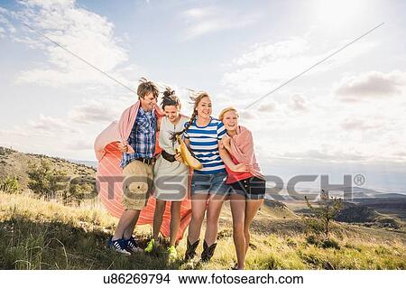 Young man and female friends wrapped blanket on hill, Bridger, Montana, USA View Large Photo Image Picture - Young man and female friends wrapped blanket on hill, Bridger, Montana, USA. Fotosearch