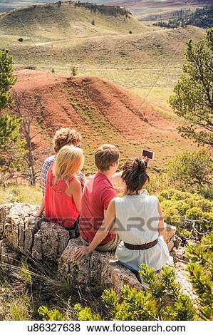 Young man and friends taking smartphone selfie on rocks, Bridger, Montana, USA View Large Photo Image Stock Photo - Young man and friends taking smartphone selfie on rocks, Bridger, Montana, USA. Fotosearch