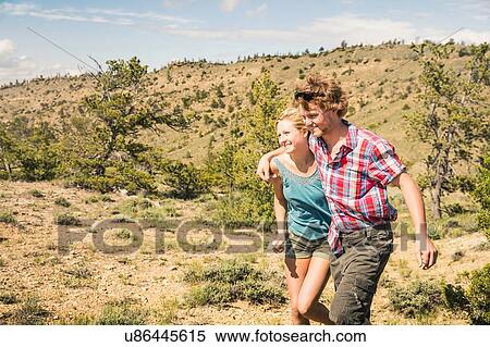 Young man and girlfriend walking in hills, Bridger, Montana, USA View Large Photo Image Stock Photography - Young man and girlfriend walking in hills, Bridger, Montana, USA. Fotosearch