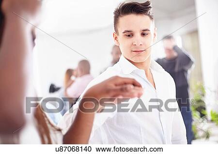 Young man in team building task holding colleagues hand View Large Photo Image Stock Image - Young man in team building task holding colleagues hand. Fotosearch