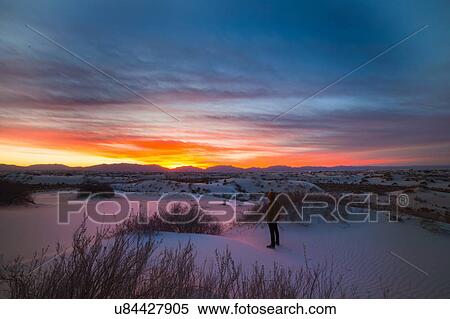 Stock Photography - "Young man standing, watching sunset, White Sands New Mexico". Fotosearch