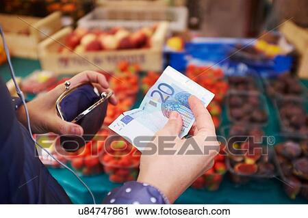"Young woman at market, taking money from purse, mid section" View Large Photo Image Stock Image - "Young woman at market, taking money from purse, mid section". Fotosearch