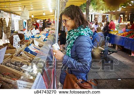 Young woman buying fresh food at market stall View Large Photo Image Stock Image - Young woman buying fresh food at market stall. Fotosearch