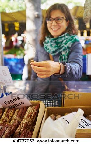 Young woman buying goods at market stall View Large Photo Image Stock Image - Young woman buying goods at market stall. Fotosearch