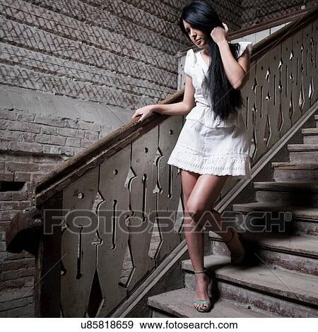 Young woman going down staircase View Large Photo Image Stock Photo - Young woman going down staircase. Fotosearch