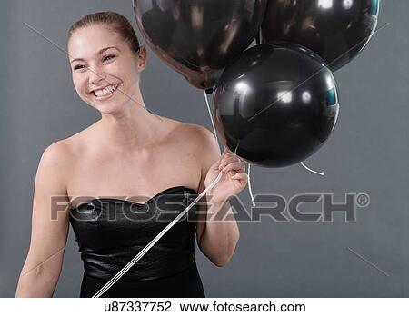 Young woman holding black balloons, grey background View Large Photo Image Stock Image - Young woman holding black balloons, grey background. Fotosearch