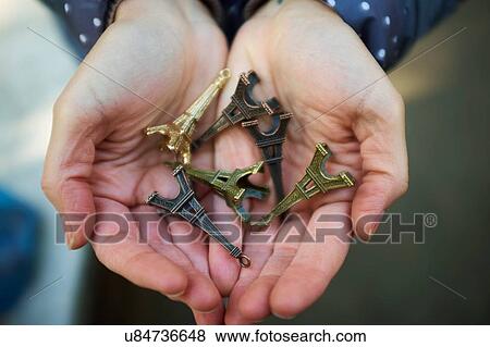 "Young woman holding Eiffel Tower souvenirs in hand, close-up" View Large Photo Image Stock Photo - "Young woman holding Eiffel Tower souvenirs in hand, close-up". Fotosearch