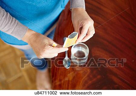 "Young woman mixing water-soluble medication from sachet, in glass of water" View Large Photo Image Stock Image - "Young woman mixing water-soluble medication from sachet, in glass of water". Fotosearch