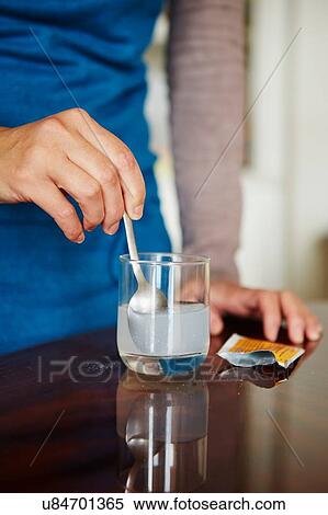 "Young woman mixing water-soluble medication from sachet, in glass of water" View Large Photo Image Stock Photography - "Young woman mixing water-soluble medication from sachet, in glass of water". Fotosearch