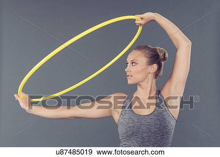Young woman practising with hula hoop, grey background View Large Photo Image Stock Photo - Young woman practising with hula hoop, grey background. Fotosearch