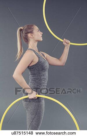 Young woman practising with hula hoop, grey background View Large Photo Image Stock Photo - Young woman practising with hula hoop, grey background. Fotosearch