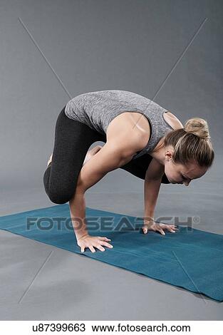 Young woman practising yoga, grey background View Large Photo Image Stock Image - Young woman practising yoga, grey background. Fotosearch