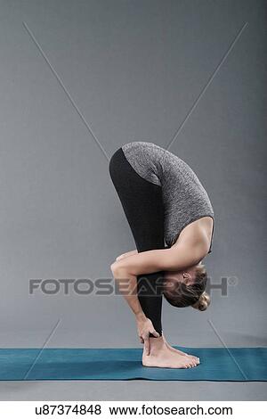 Young woman practising yoga, grey background View Large Photo Image Stock Photo - Young woman practising yoga, grey background. Fotosearch