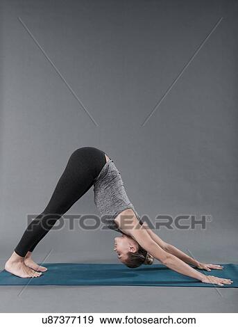 Young woman practising yoga, grey background View Large Photo Image Stock Photo - Young woman practising yoga, grey background. Fotosearch