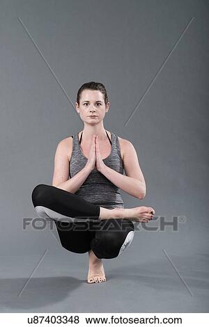 Young woman practising yoga, grey background View Large Photo Image Stock Photo - Young woman practising yoga, grey background. Fotosearch