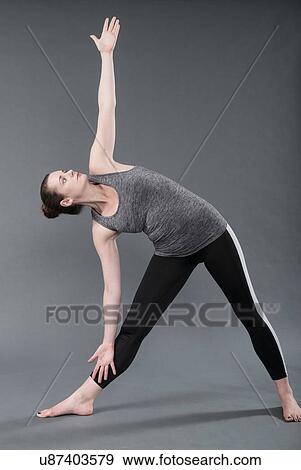 Young woman practising yoga, grey background View Large Photo Image Stock Photo - Young woman practising yoga, grey background. Fotosearch