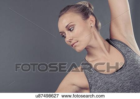 Stock Photo - Young woman practising yoga, grey background. Fotosearch