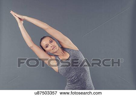 Young woman practising yoga, grey background View Large Photo Image Stock Photo - Young woman practising yoga, grey background. Fotosearch