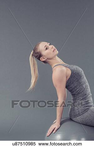 Young woman practising yoga with gym ball, grey background View Large Photo Image Stock Photography - Young woman practising yoga with gym ball, grey background. Fotosearch