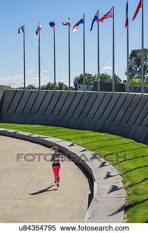 Stock Photography - Young woman running on sports track. Fotosearch