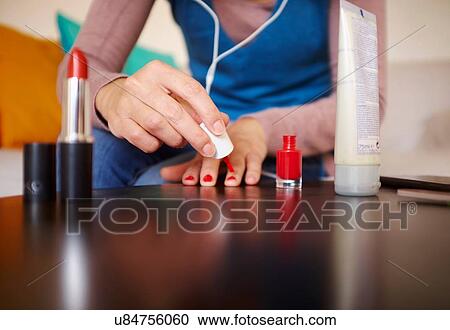 "Young woman sitting at table applying nail varnish, mid section" View Large Photo Image Stock Image - "Young woman sitting at table applying nail varnish, mid section". Fotosearch