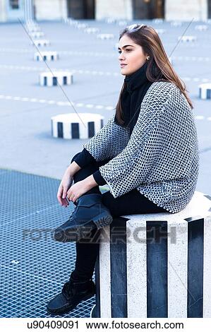 Young woman sitting on striped concrete stool, Le Palais Royal, Paris, France View Large Photo Image Stock Image - Young woman sitting on striped concrete stool, Le Palais Royal, Paris, France. Fotosearch